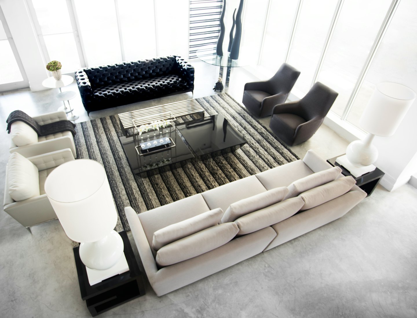 Modern living room furniture arranged on a striped rug.